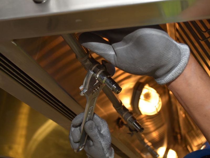 Handwerker montiert mit einem Schraubenschlüssel eine Rohrverbindung