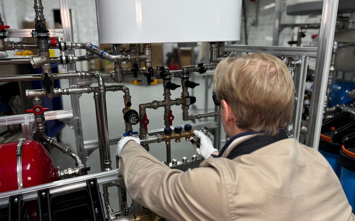 Heizungstechniker kalibriert einen modernen Heizungsverteiler in der Werkstatt