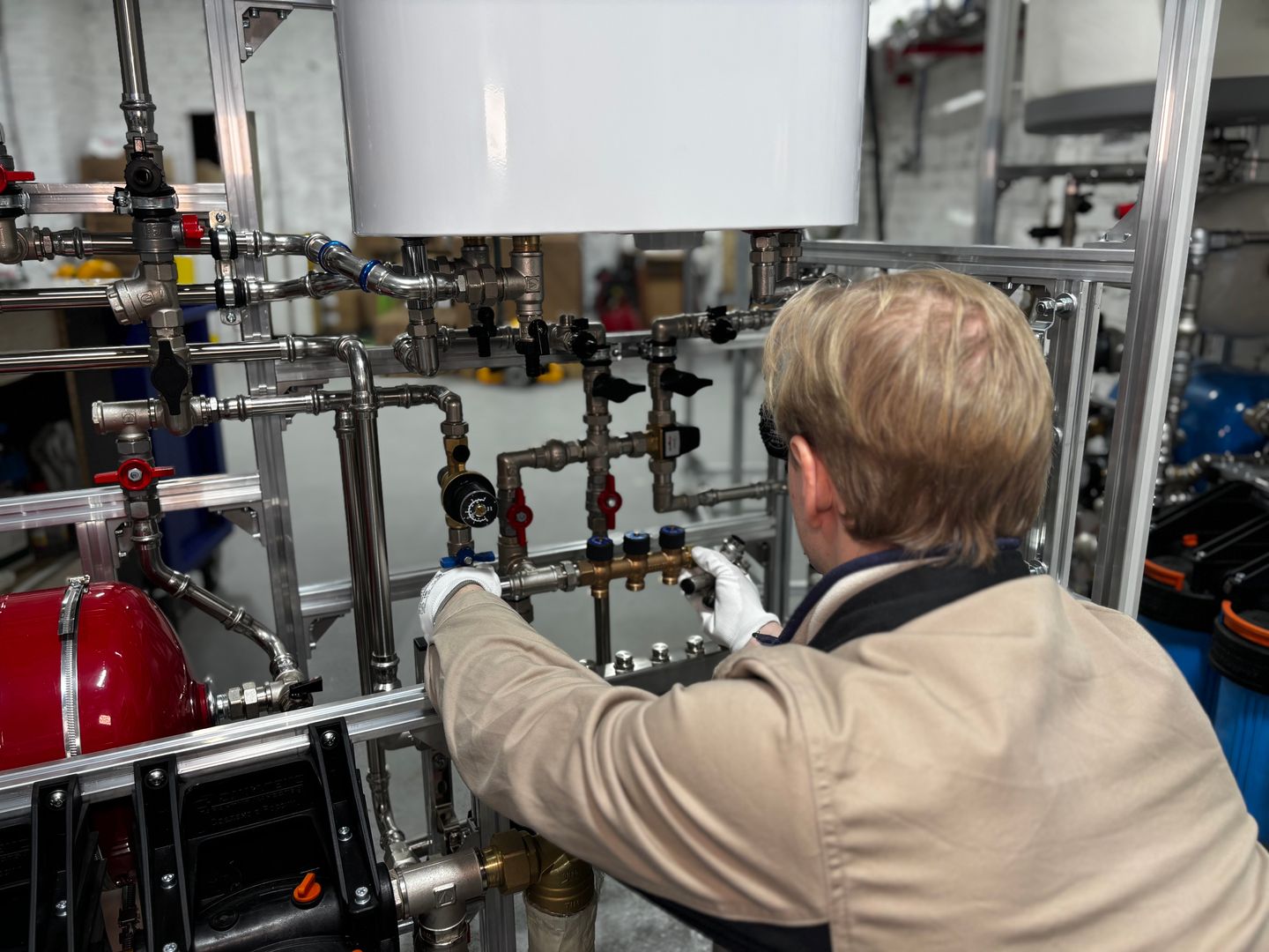 Heizungstechniker kalibriert einen modernen Heizungsverteiler in der Werkstatt